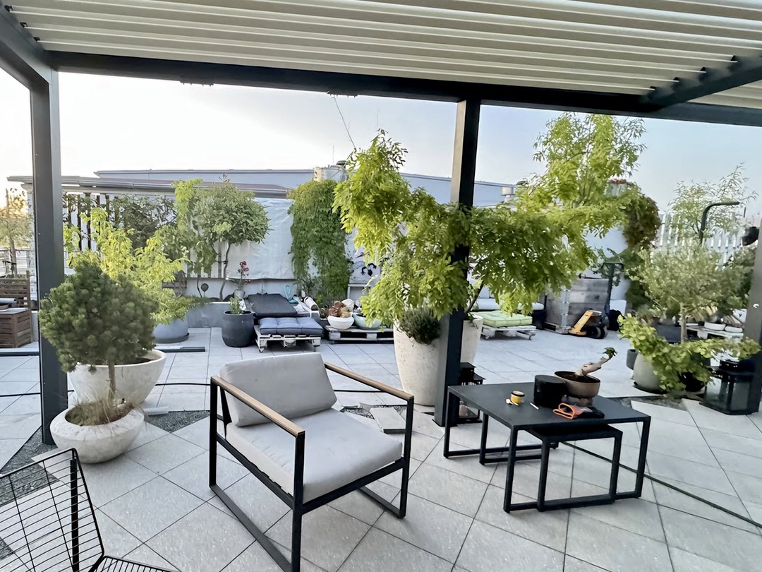 Terasa s bioklimatickou pergolou obklopená velkými květináči s rostlinami
