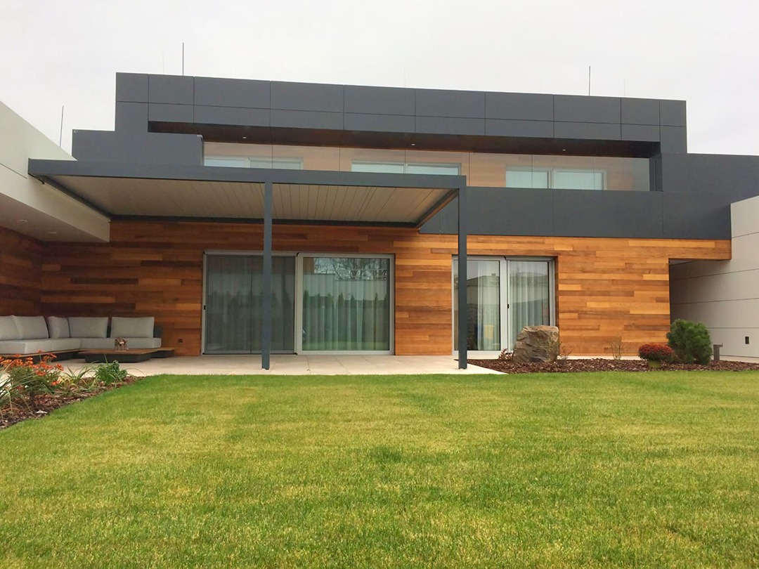 Pergola ukotvená k fasáde moderného rodinného domu