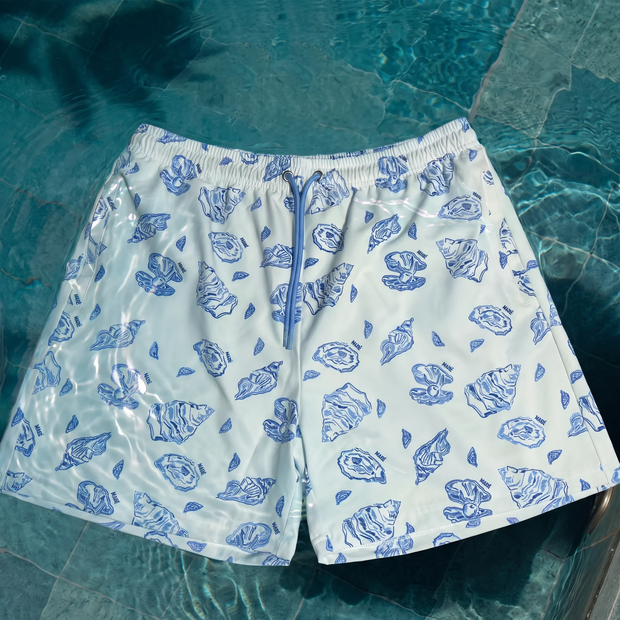 Witte zwembroek met blauwe oesterprint in het water
