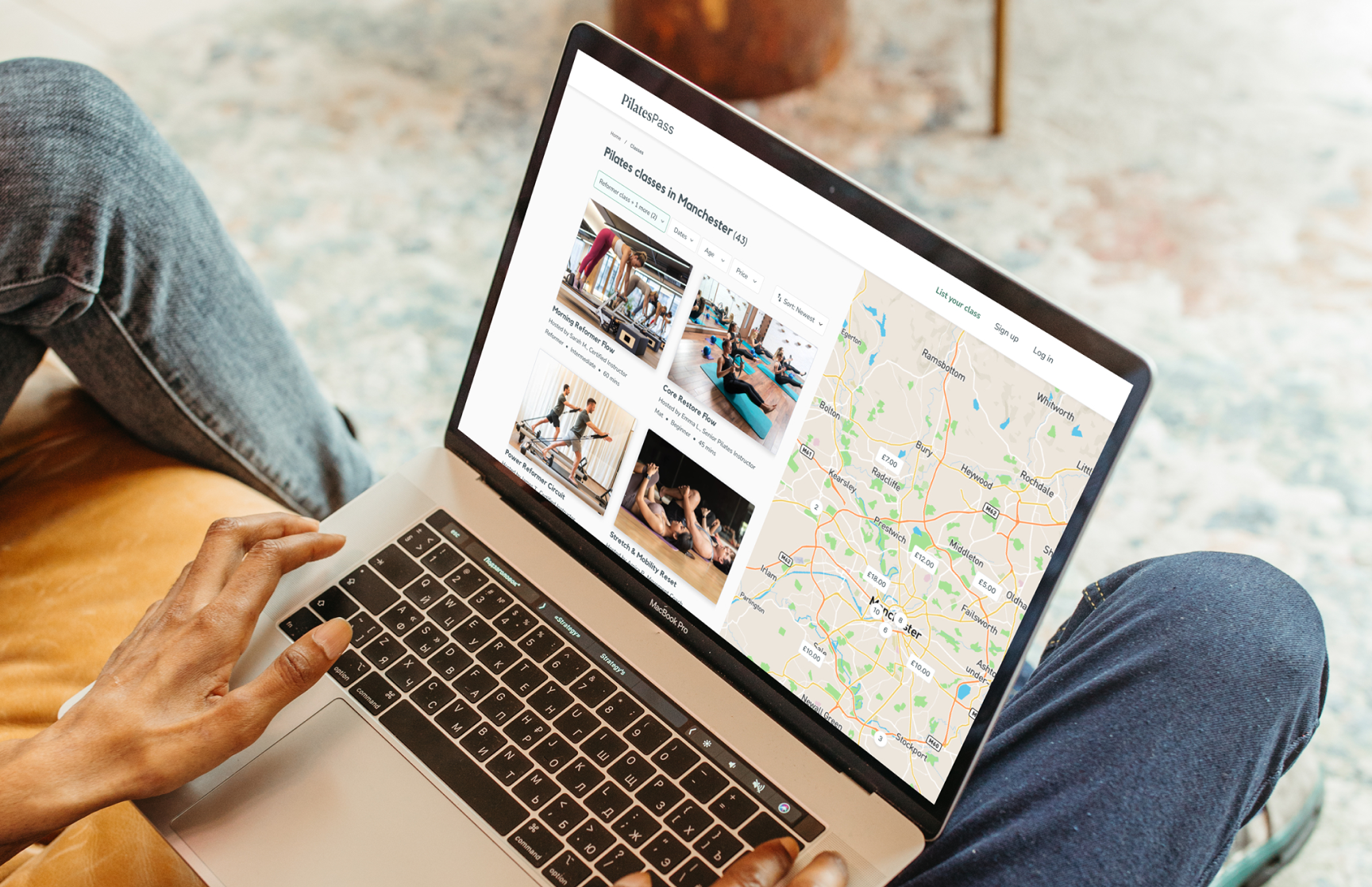Photograph of someone using a macbook. The screen shows the search page for PilatesPass