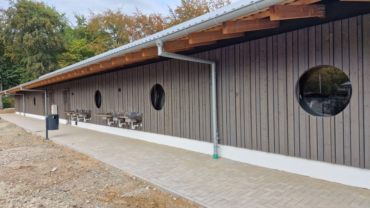 Das neue Sanitärgebäude in Überland Vlotho bietet modernsten Komfort für Camper: Neben integrierter Rezeption stehen barrierefreie Bäder, Kinder- und Mietbäder sowie großzügige Unisex-Bereiche und Spülplätze zur Verfügung.