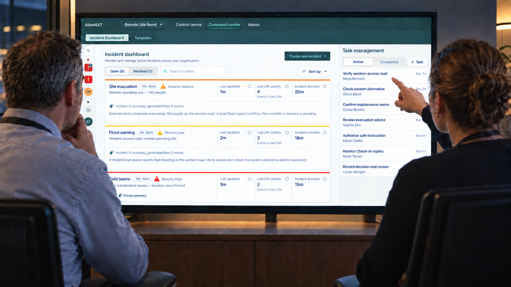 Two colleagues reviewing evacuation advice and flood reports on the AtlasNXT Incident Dashboard, with one pointing to the route-verification task
