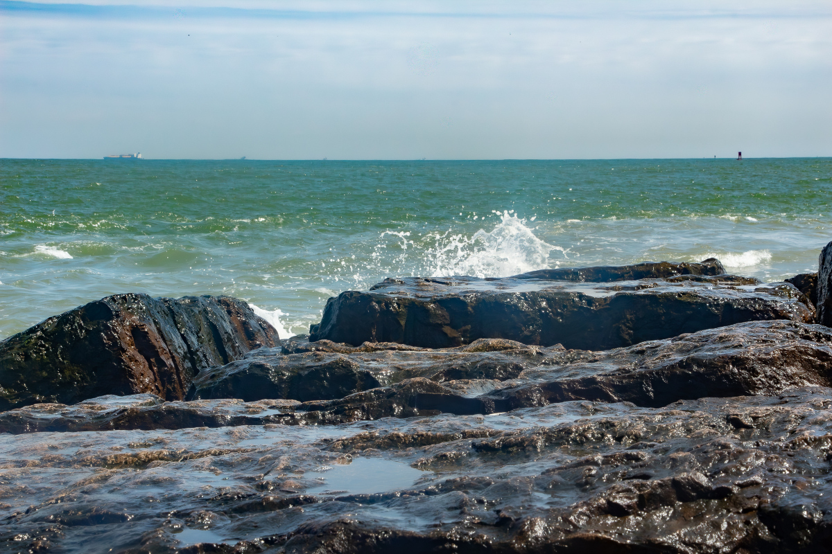 ocean waves splashing onto a jetty