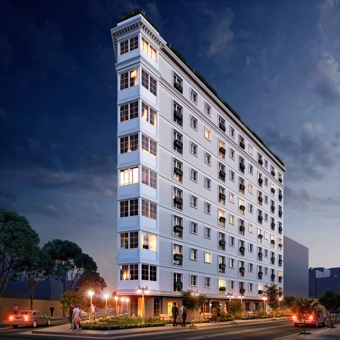 Edificio blanco triangular de ocho pisos con ventanas iluminadas y personas en la calle al anochecer.