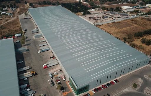 Vista aérea de un gran centro de distribución con varios camiones de carga en las bahías de carga.