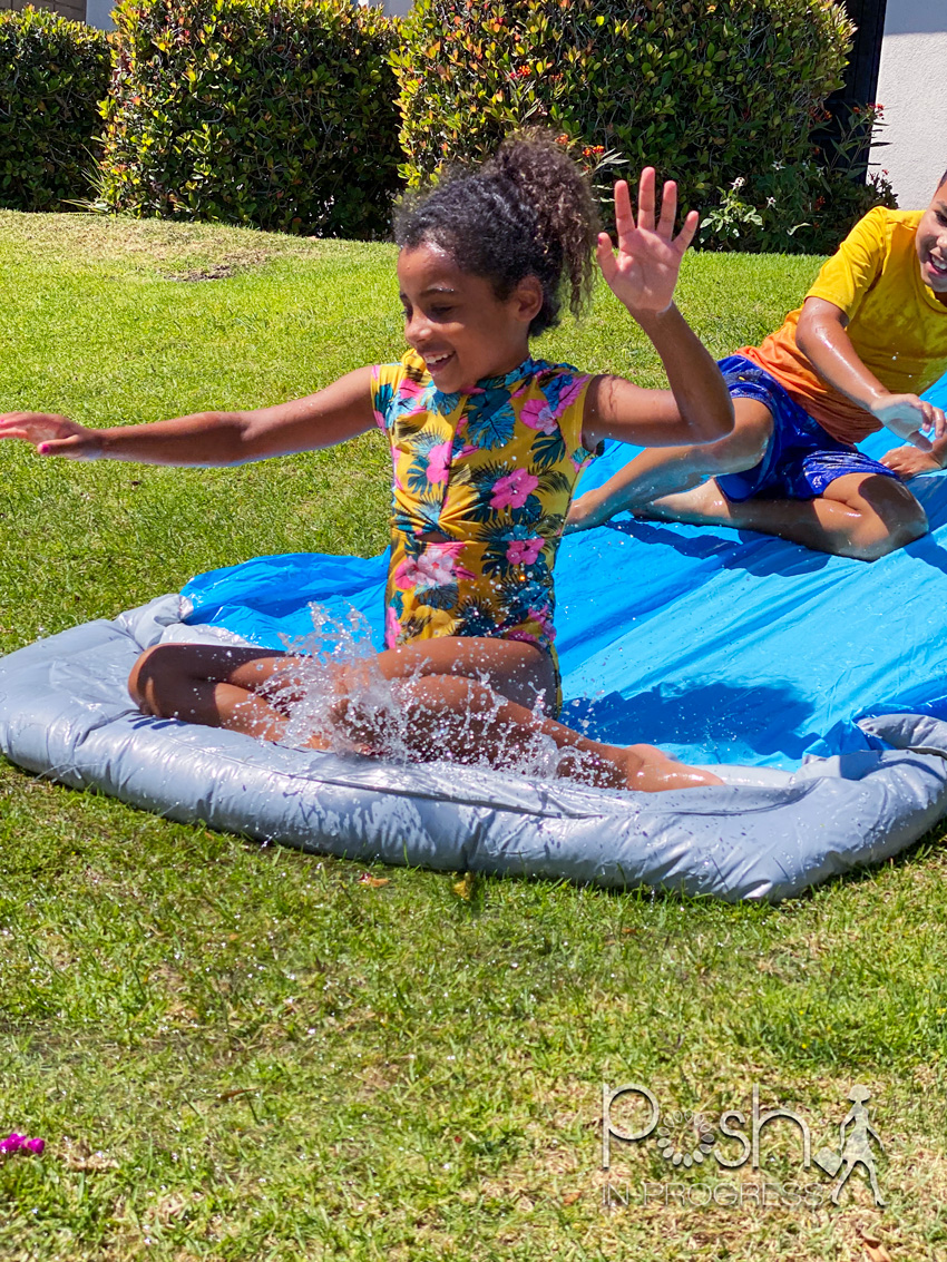 backyard water toys for kids 2 | Backyard Water Toys by popular LA motherhood blog: image of a young boy and girl on a slip n slide. 