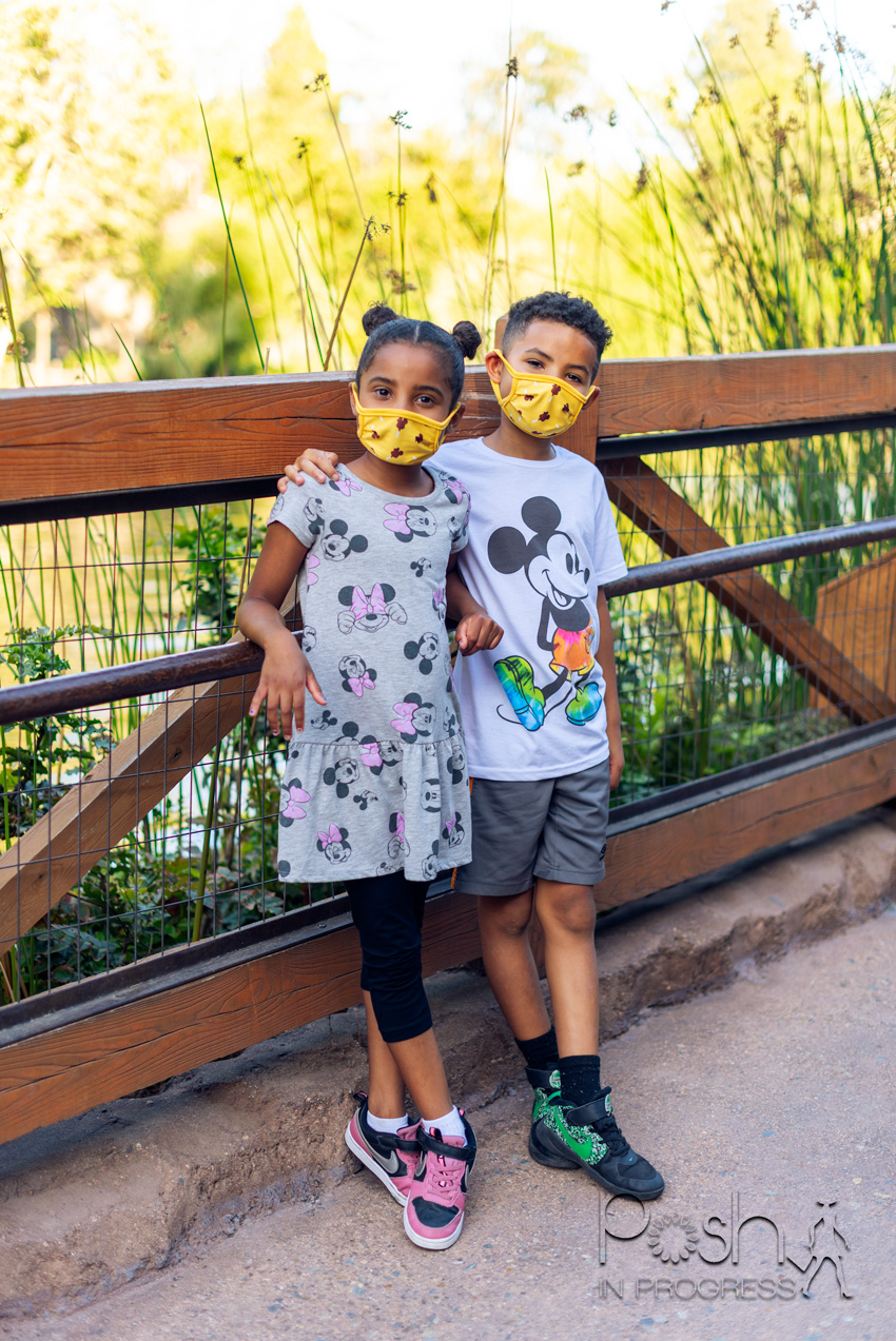  Disneyland Reopening by popular LA lifestyle blog, Posh in Progress: image of a boy and girl standing together on a bridge and wearing Mickey and Minnie Mouse shirts. 