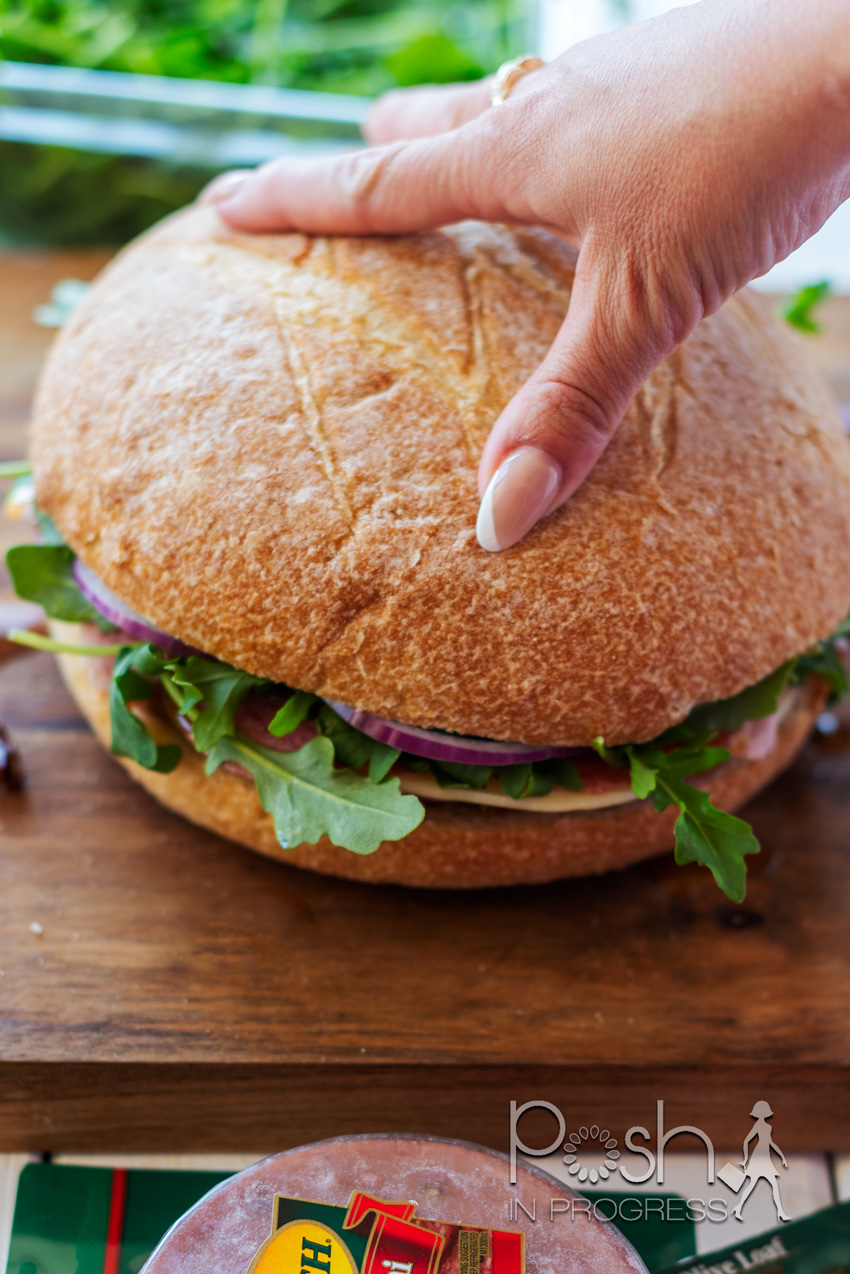 muffuletta recipe | Muffuletta Recipe by popular LA lifestyle blog, Posh in Progress: image of a woman making a muffuletta sandwich. 