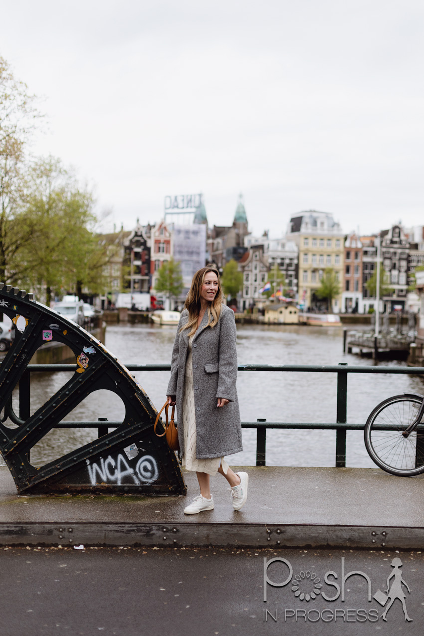 Amsterdam canal houses with a packed suitcase for travel