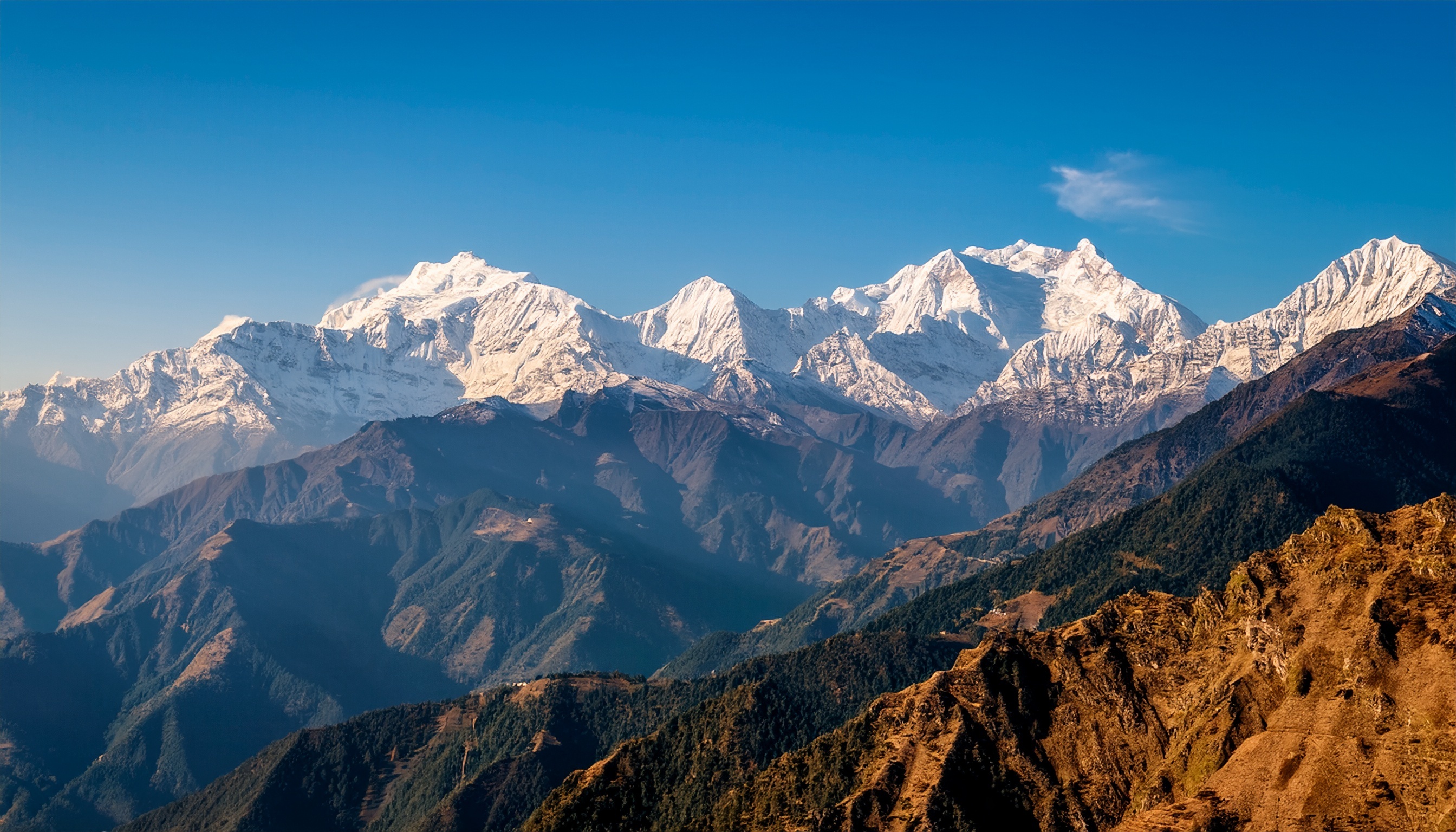 Snow-capped mountains under a clear blue sky symbolizing ambition and growth.