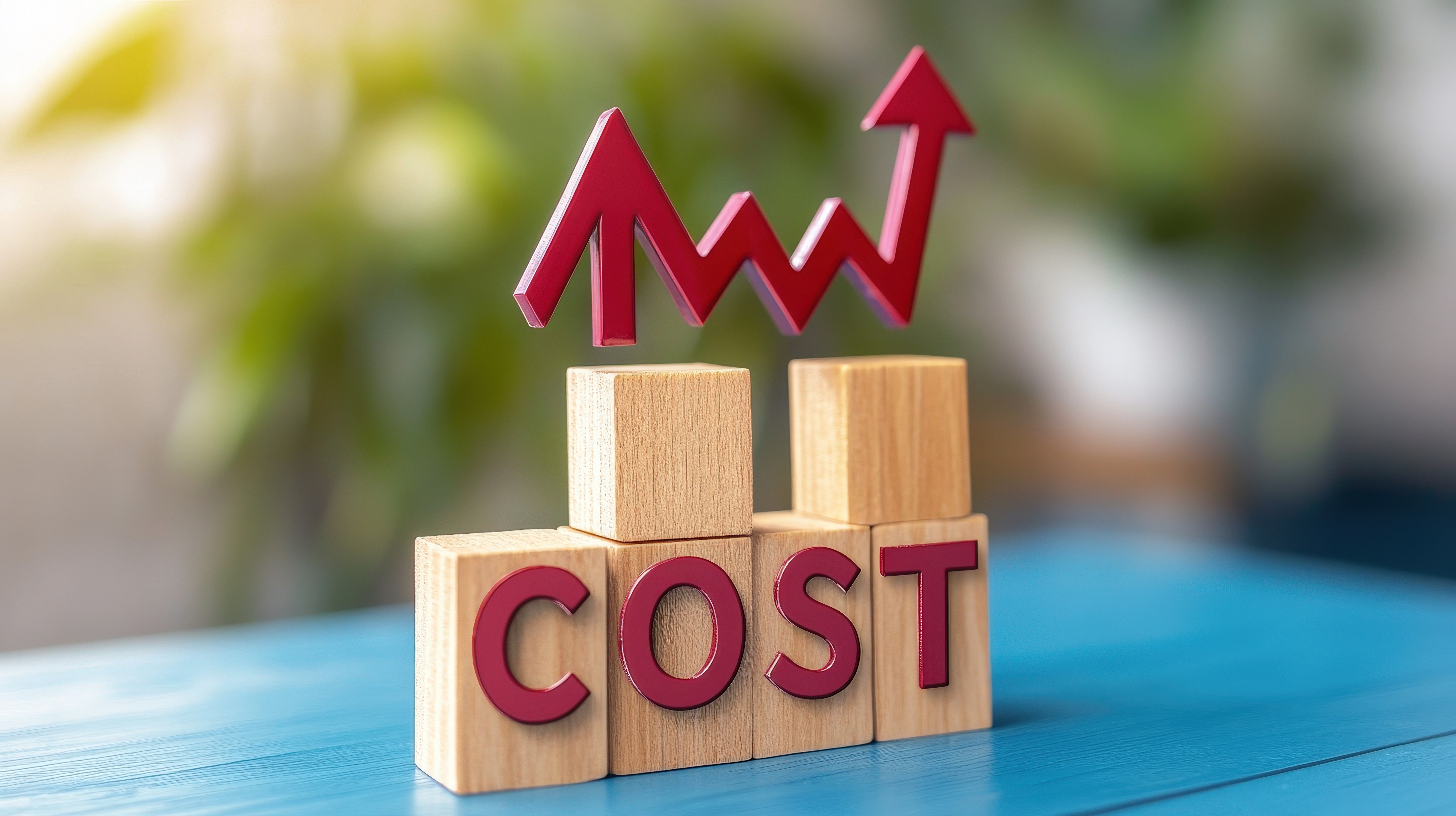 The banner image features wooden alphabet blocks spelling "COST" in the foreground, with a red upward-trending arrow graphic in the background.