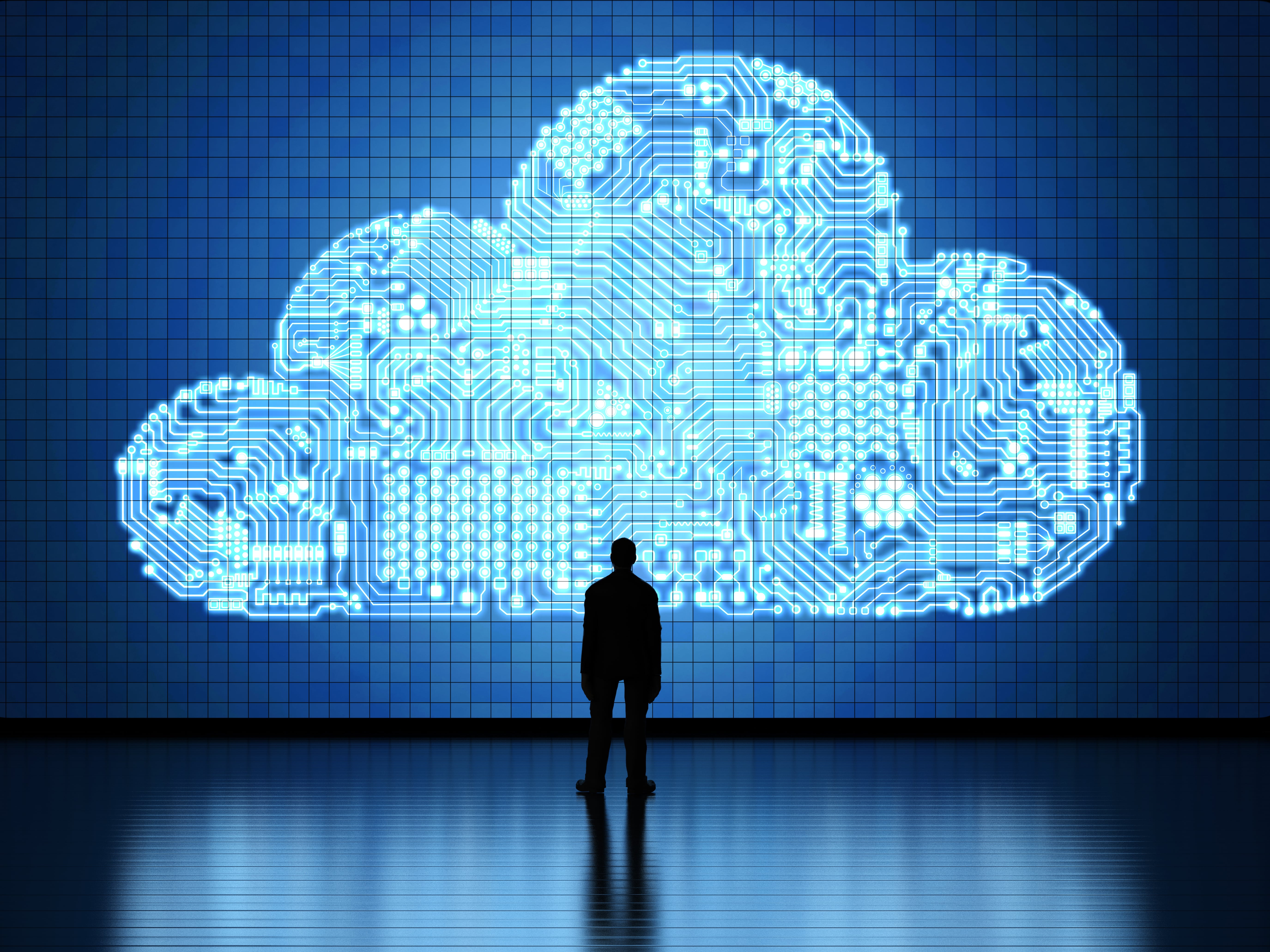 Silhouette of a person standing before a glowing digital cloud made of circuit patterns, representing cloud computing infrastructure, data connectivity, and technological foresight.
