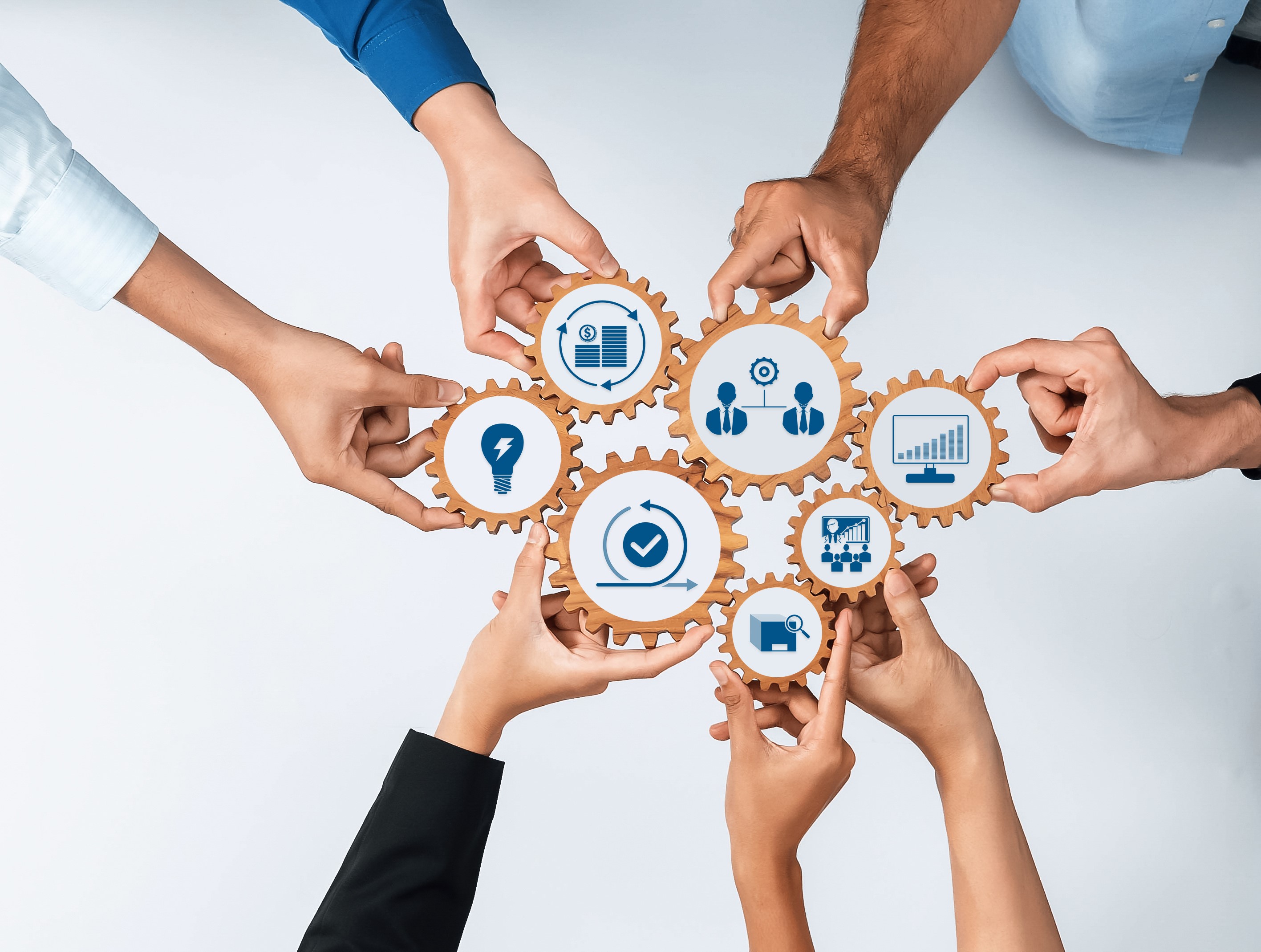 A group of diverse hands holds up a circle of interconnected blue gears, which contain icons for teamwork, data, and business, symbolizing "University Collaboration Programs."