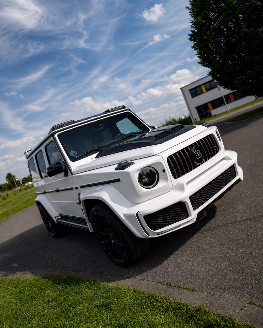 Weißer SUV mit schwarzer Motorhaube und Design auf Straße unter blauem Himmel.
