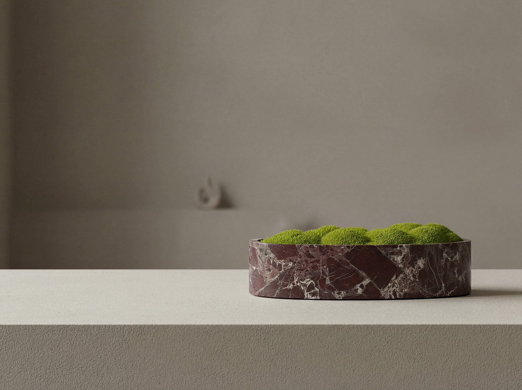 Marmorschale mit grünem Moos auf einem Stein Sideboard in einem minimalistischem Ambiente