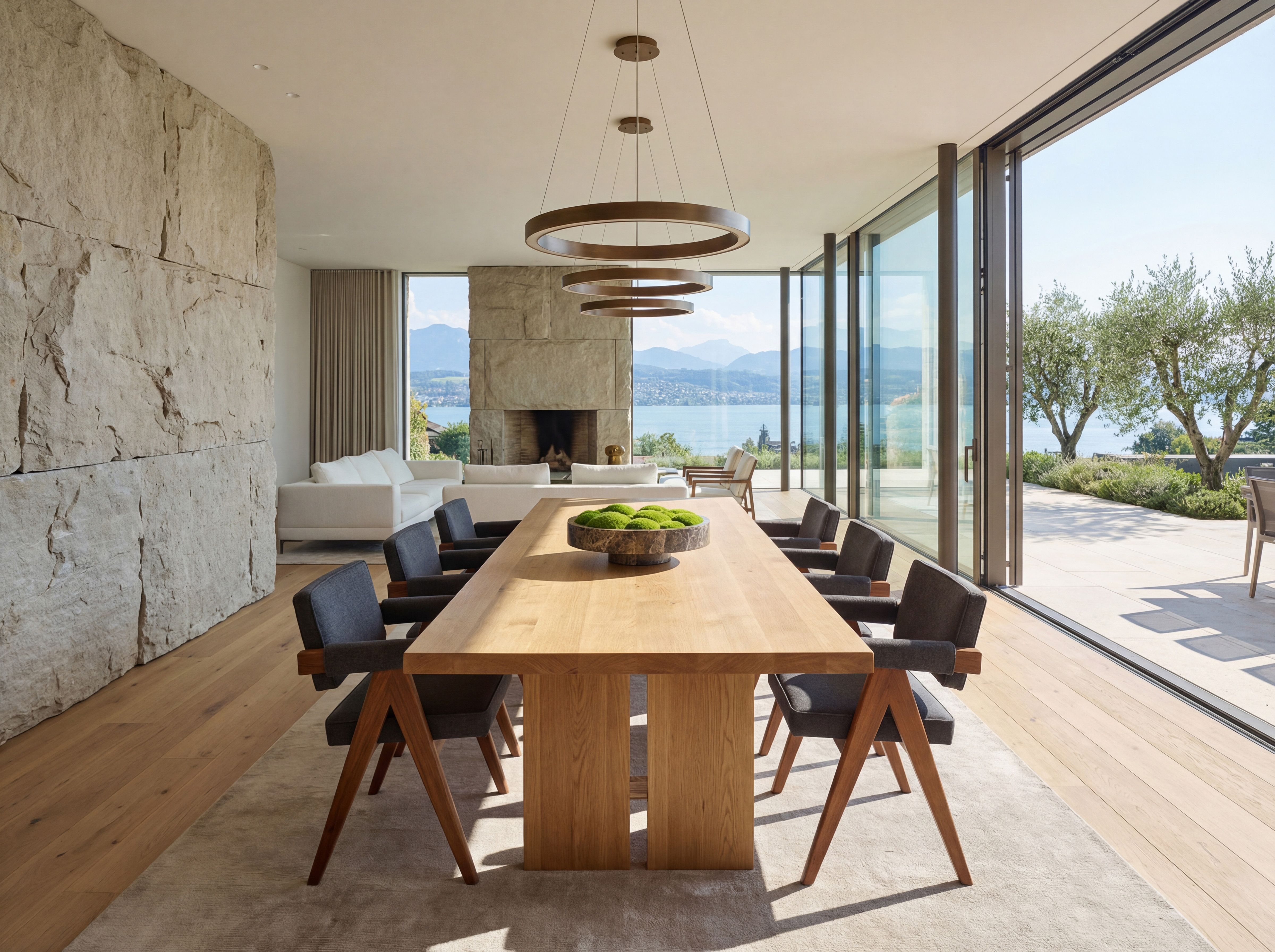 Marmorschale mit grünem Moos-Arrangement auf einem massiven Esstisch in einem modernen Penthouse am See