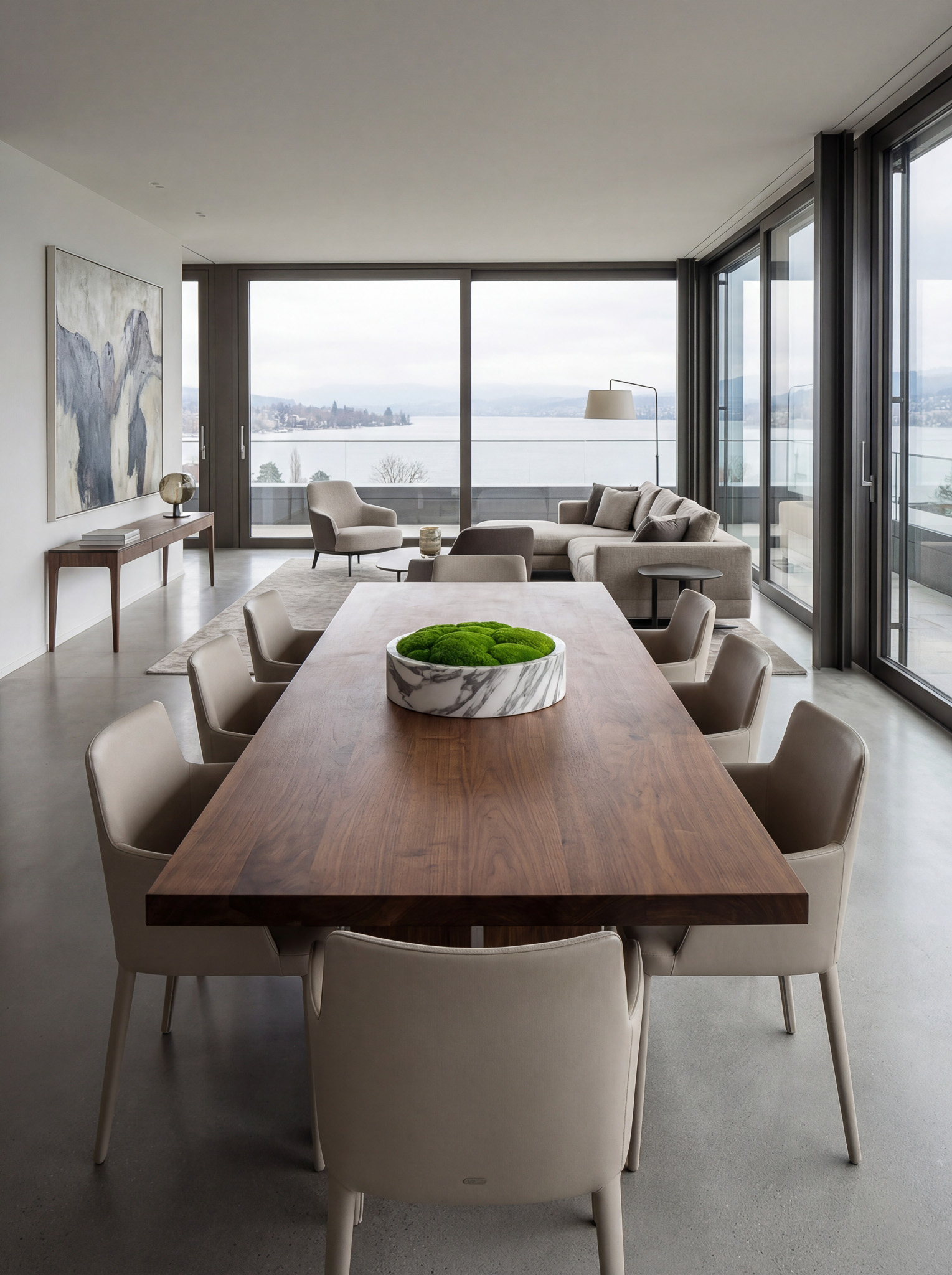 Marmorschale mit grünem Moos auf einem ovalen Esstisch in einem exklusiven Wohnambiente mit Panorama-Seesicht