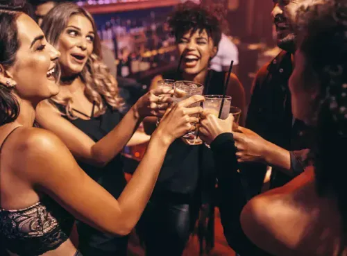A lively group raising their glasses in celebration at an Ambl-recommended venue, found using the app’s instant booking feature.