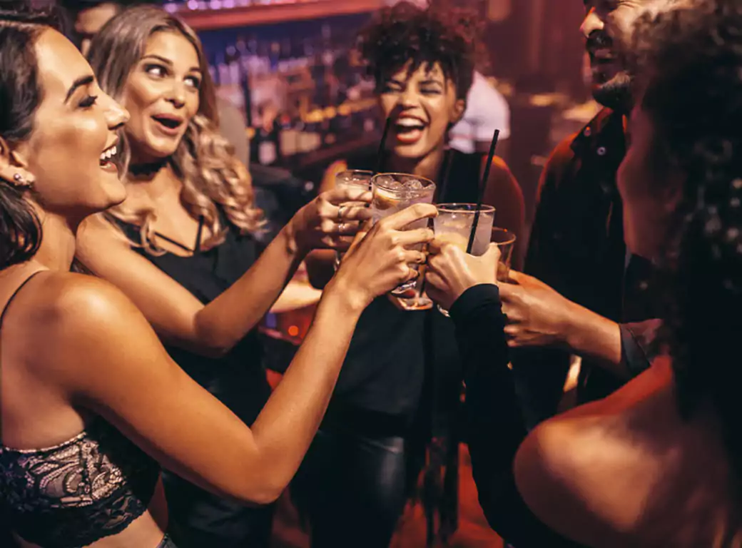 A lively group raising their glasses in celebration at an Ambl-recommended venue, found using the app’s instant booking feature.