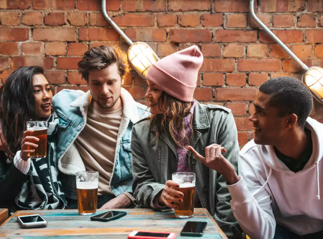 A group of friends relaxing at a cozy pub, highlighting how Ambl helps users find the perfect spot for any occasion.