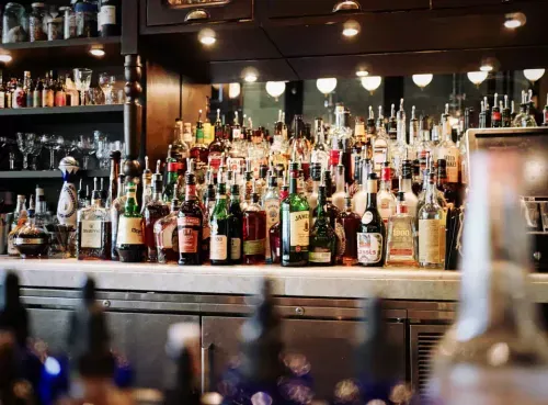 A well-stocked bar with a vast selection of premium spirits and whiskey bottles, showcasing the high-end venues available for booking through the Ambl app.