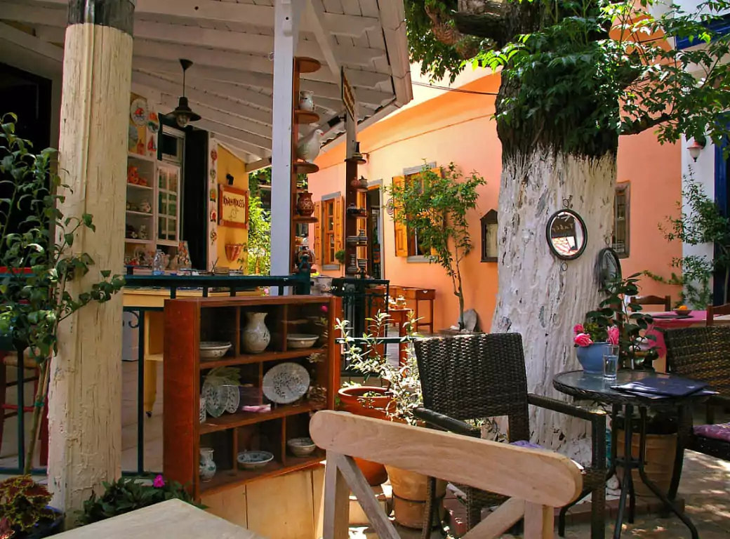 A charming outdoor café in Soho, London, featuring rustic wooden furniture, lush greenery, and a relaxed ambiance—an ideal spot for alfresco dining. Discover Soho’s best hidden gems with Ambl.