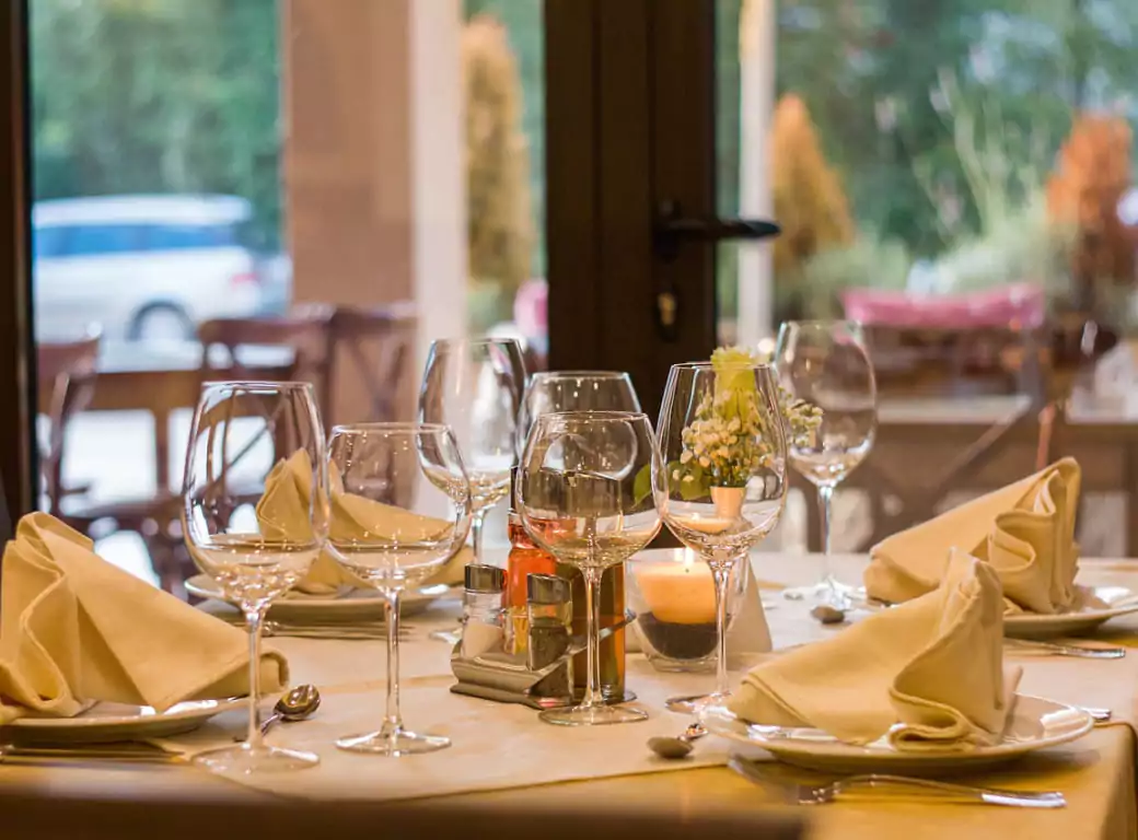 A beautifully set fine dining table in a Mayfair restaurant, featuring elegant glassware, folded napkins, and soft candlelight. Find last-minute tables at London’s most exclusive restaurants with Ambl.
