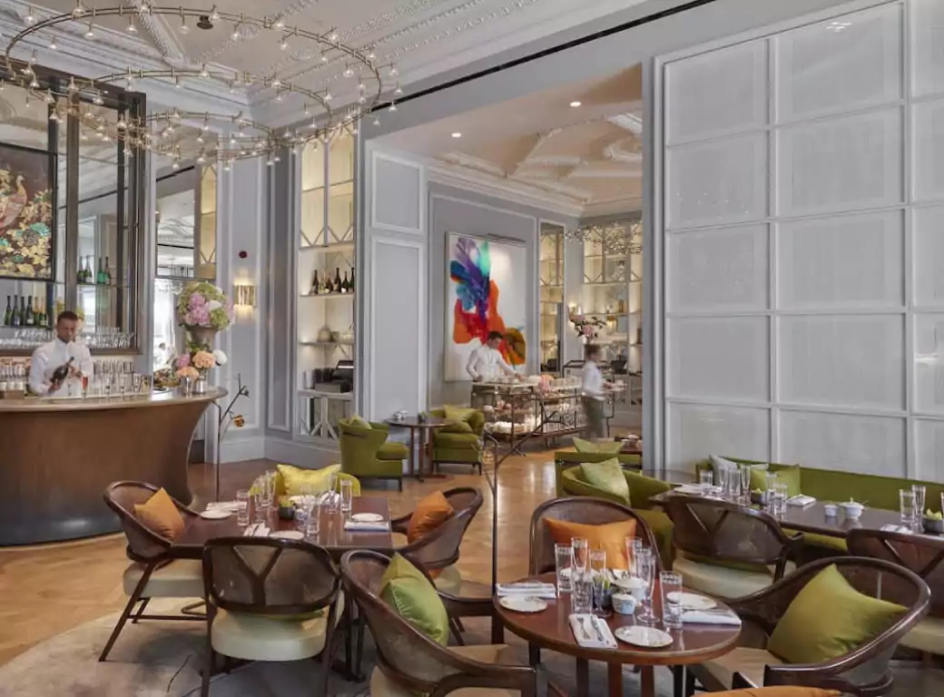 An elegant and modern restaurant with stylish seating, a chic bar, and stunning chandeliers, perfect for a sophisticated dining experience. Find the best spots like this effortlessly with Ambl.