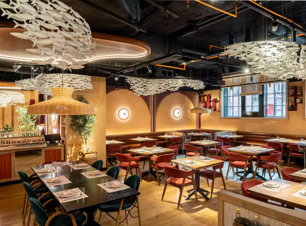 A stylish and contemporary restaurant near Bond Street with elegant décor, featuring warm lighting, chic wooden furnishings, and intricate ceiling installations—easily discover unique dining experiences like this with Ambl.