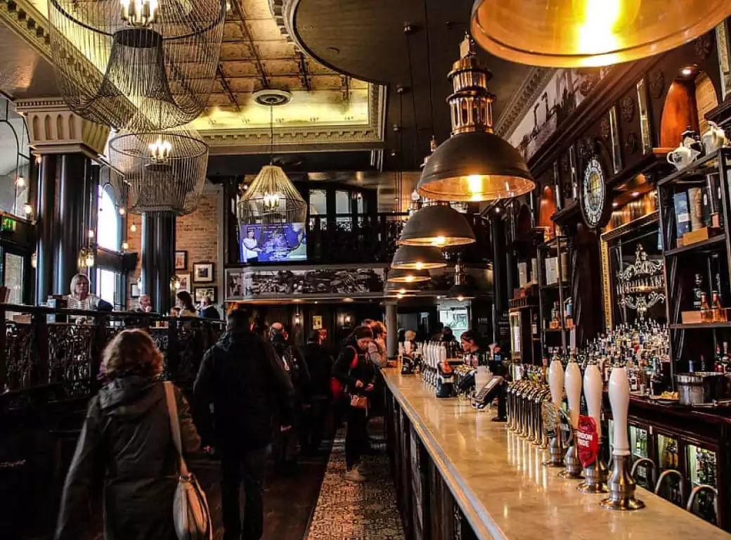 A grand and atmospheric pub with ornate chandeliers, a stunning bar lined with craft beers, and a lively crowd—perfect for a memorable birthday celebration. Find the best birthday venues effortlessly with Ambl.