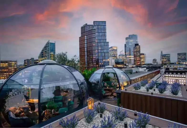 A scenic rooftop bar with stylish outdoor seating, offering stunning city views. Discover London’s best rooftop bars with Ambl.