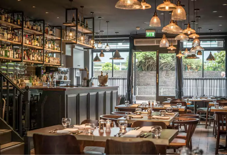 A stylish and industrial-chic restaurant with warm lighting and a fully stocked bar at Black Rock. Find hidden gems like this with Ambl.