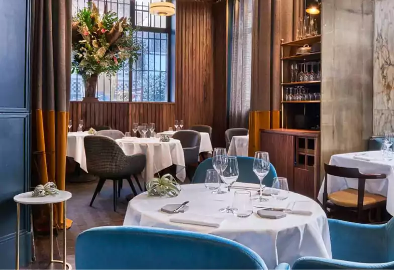 A refined and intimate French dining space with elegant decor and plush seating, ideal for a sophisticated evening with Ambl.