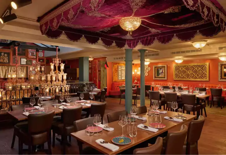 A vibrant Indian restaurant adorned with intricate decor, rich colors, and chandeliers, bringing a unique dining experience to Ambl users.