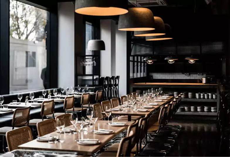 A sophisticated restaurant with a moody, industrial-chic aesthetic and dimly lit ambiance, making it an exciting discovery on Ambl.