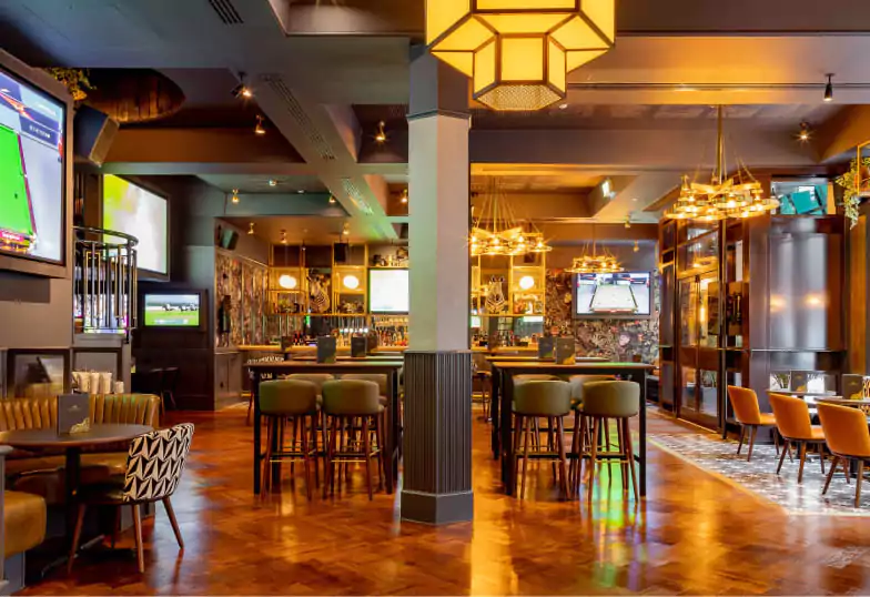 A stylish gastropub with plush green and orange seating, modern decor, and an extensive beer and cocktail selection. A cozy yet trendy space for casual dining and drinks. Discover more gastropubs on Ambl.