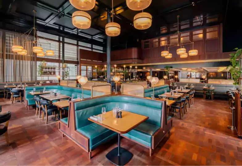 A stylish waterfront restaurant with teal leather booths, modern lighting, and a welcoming ambiance, perfect for steak and seafood lovers. Discover more waterfront gems on Ambl.