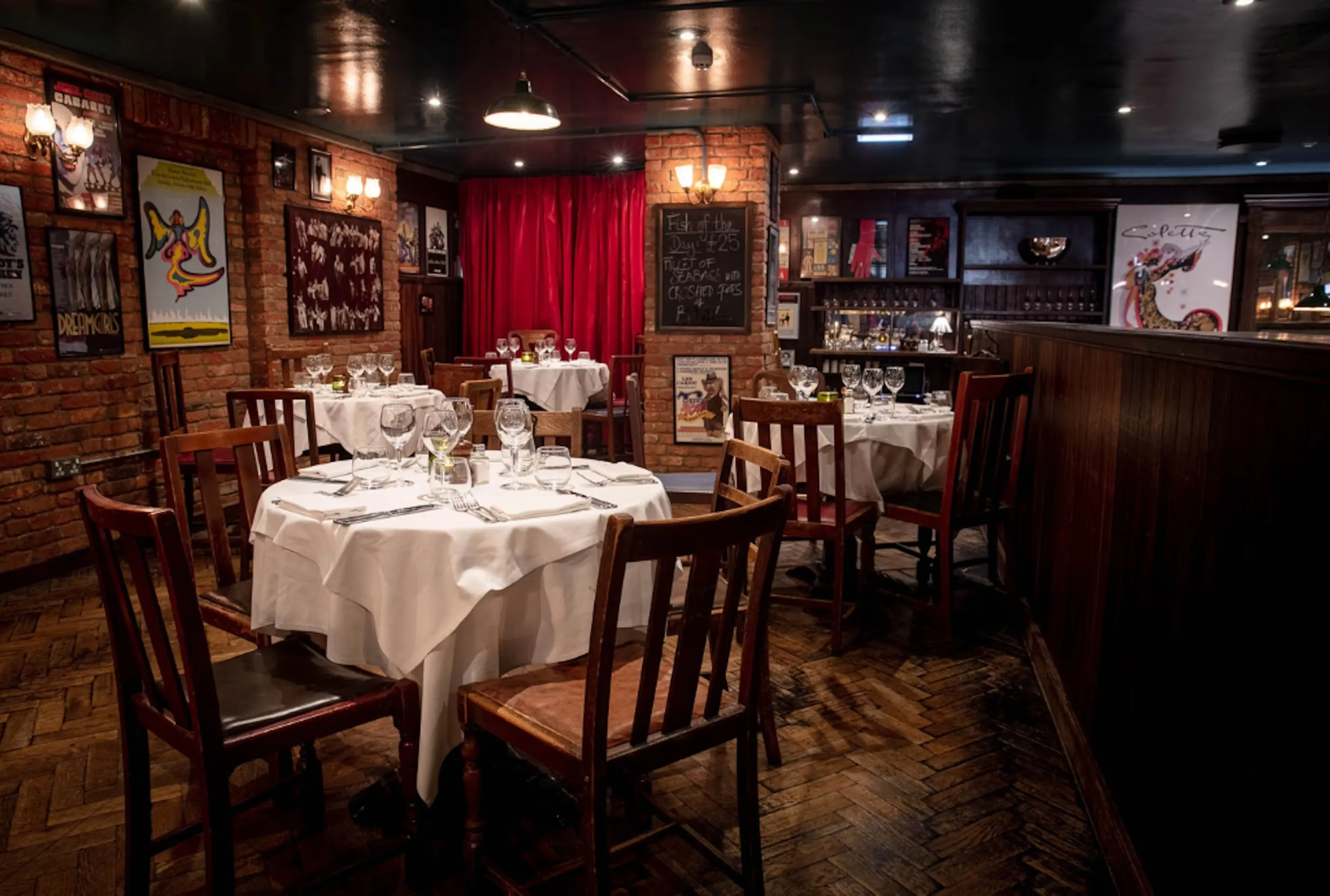 A stylish and modern bar with high stools, plush seating, copper beer tanks, and multiple TV screens, offering a vibrant atmosphere. One of the Ambl-listed venues perfect for post-theatre drinks or watching live sports.