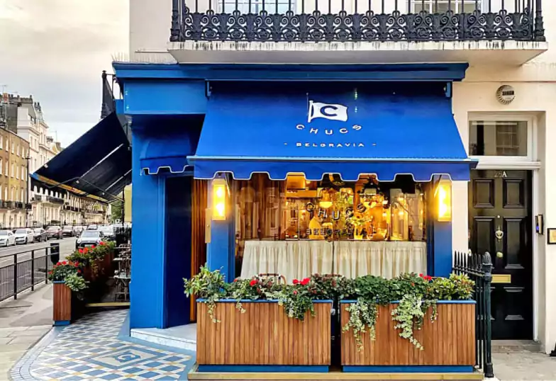 A charming Italian bistro with a stylish blue façade and cozy terrace at Chucs Belgravia. Find venues like this with Ambl.
