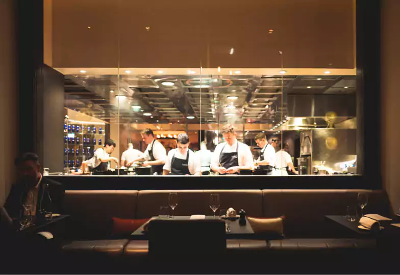 A beautifully plated Michelin-star dish featuring a perfectly seared cut of meat, delicate vegetables, and artistic garnishes on a minimalist ceramic plate. Discover fine dining with Ambl.