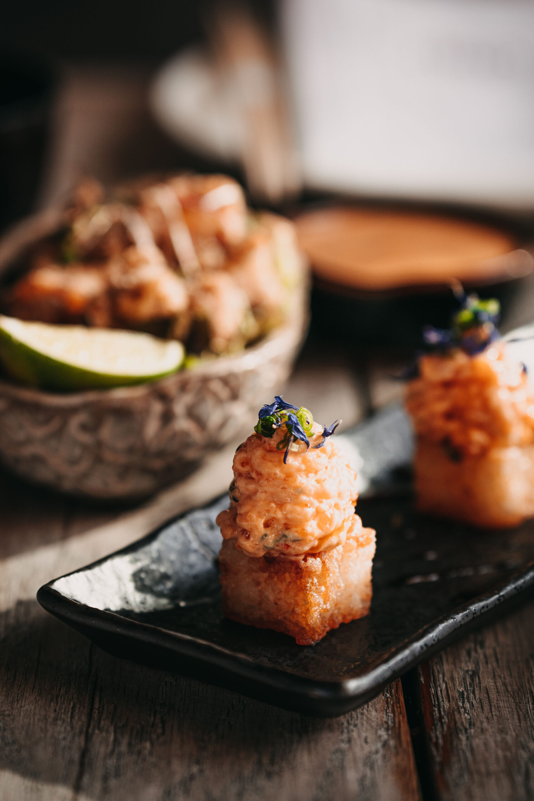 Elegant crispy rice and spicy salmon, modern plating from Clap London.