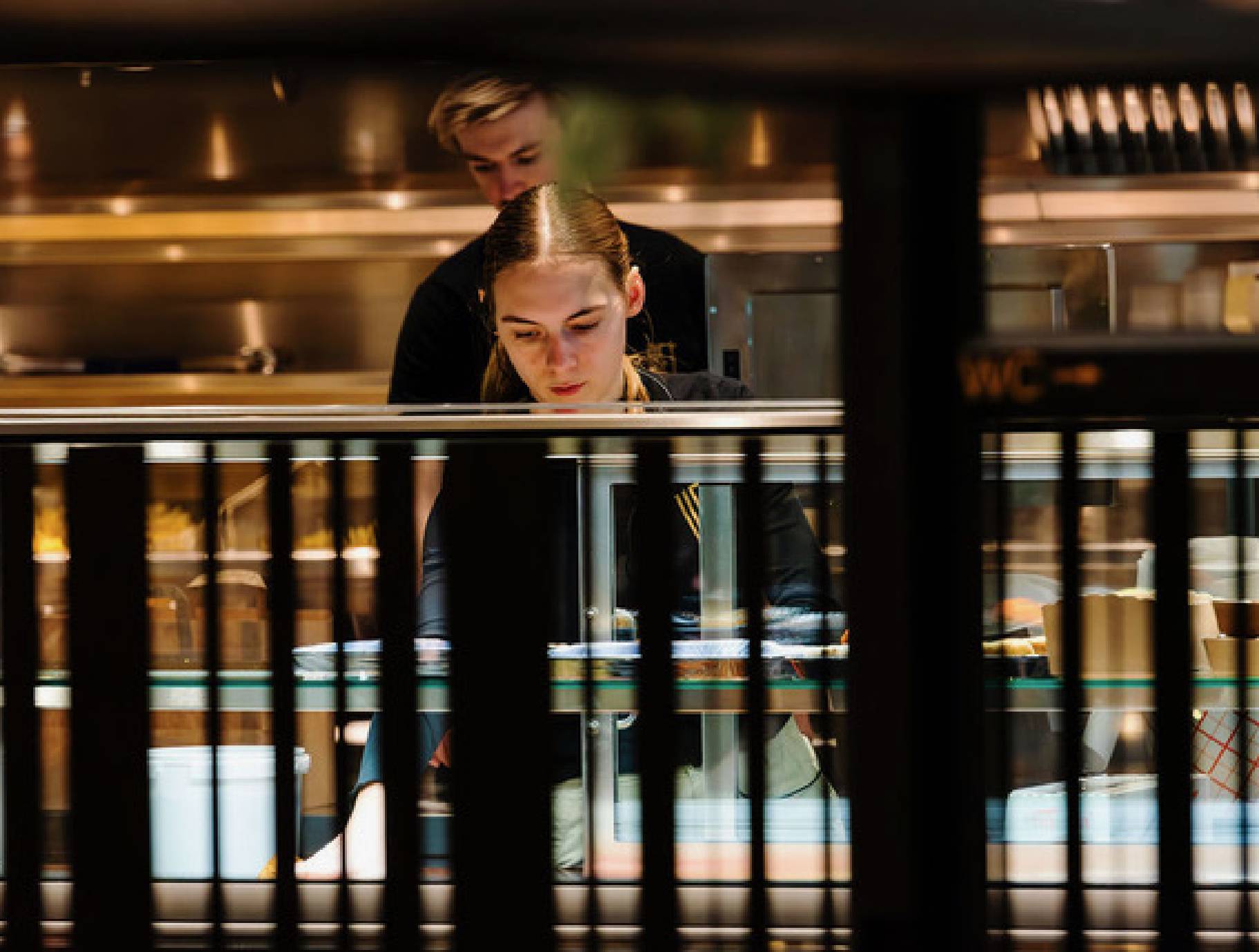 Chef in professionele keuken, gefocust op koken, achter toonbank.