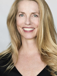 Smiling woman with long blonde hair wearing a black top against a light background.