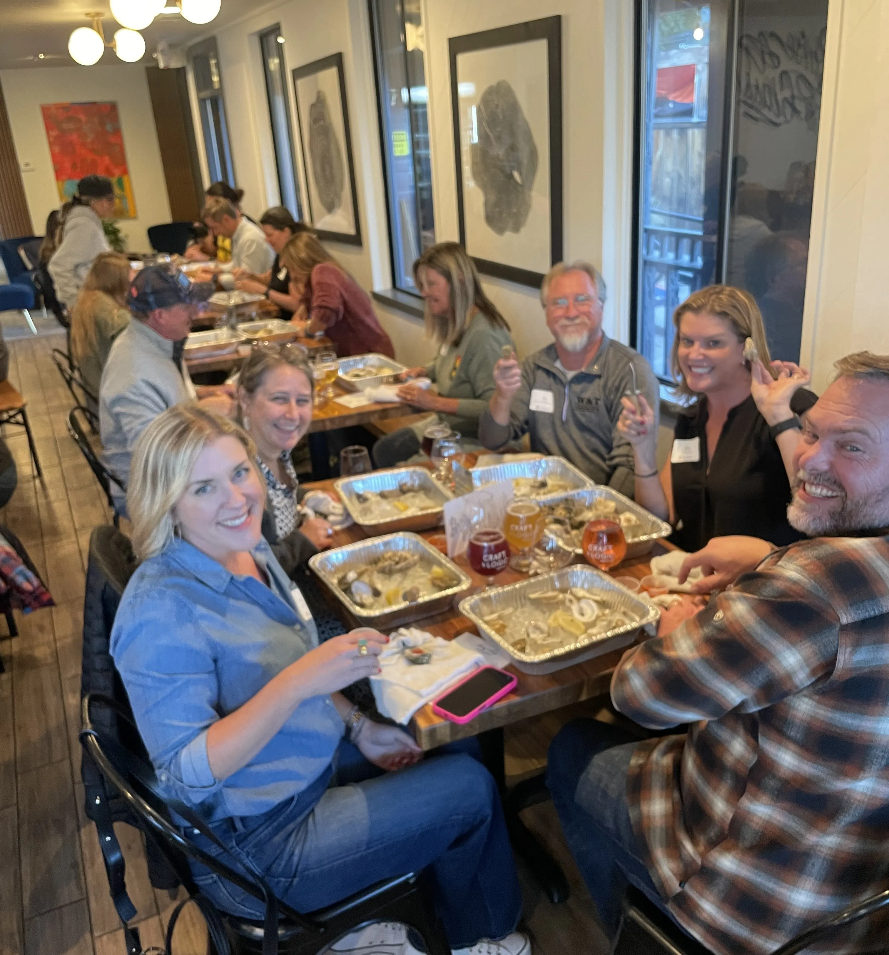 Calm river flowing through rocky banks surrounded by pine trees under a blue and pink evening sky.