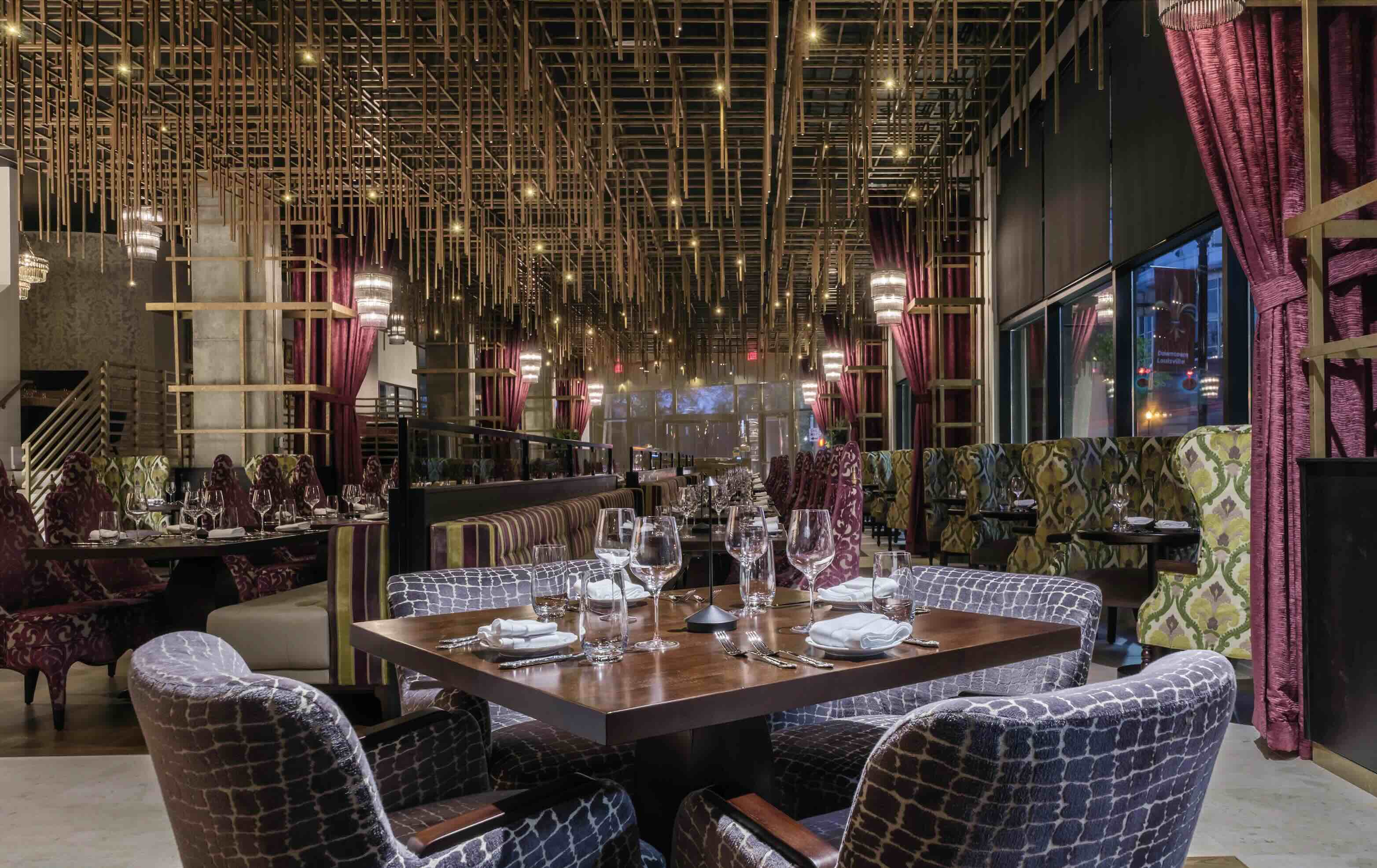 A restaurant with a wooden table surrounded by purple chairs.