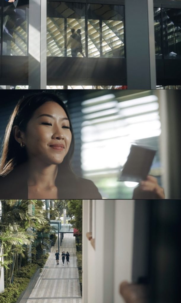 Woman holding tablet looking out window with urban cityscape views in background