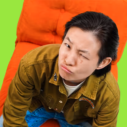 Young person in mustard jacket posing against vibrant green and red background