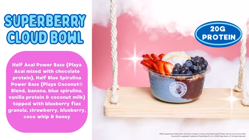A colorful smoothie bowl topped with strawberries, blueberries, granola, and coconut whip, served on a swing backdrop.