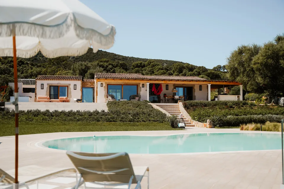 FitnWrk Retreat Finca auf Sardinien Bild von außen am Tag mit Sicht auf Pool und die Finca