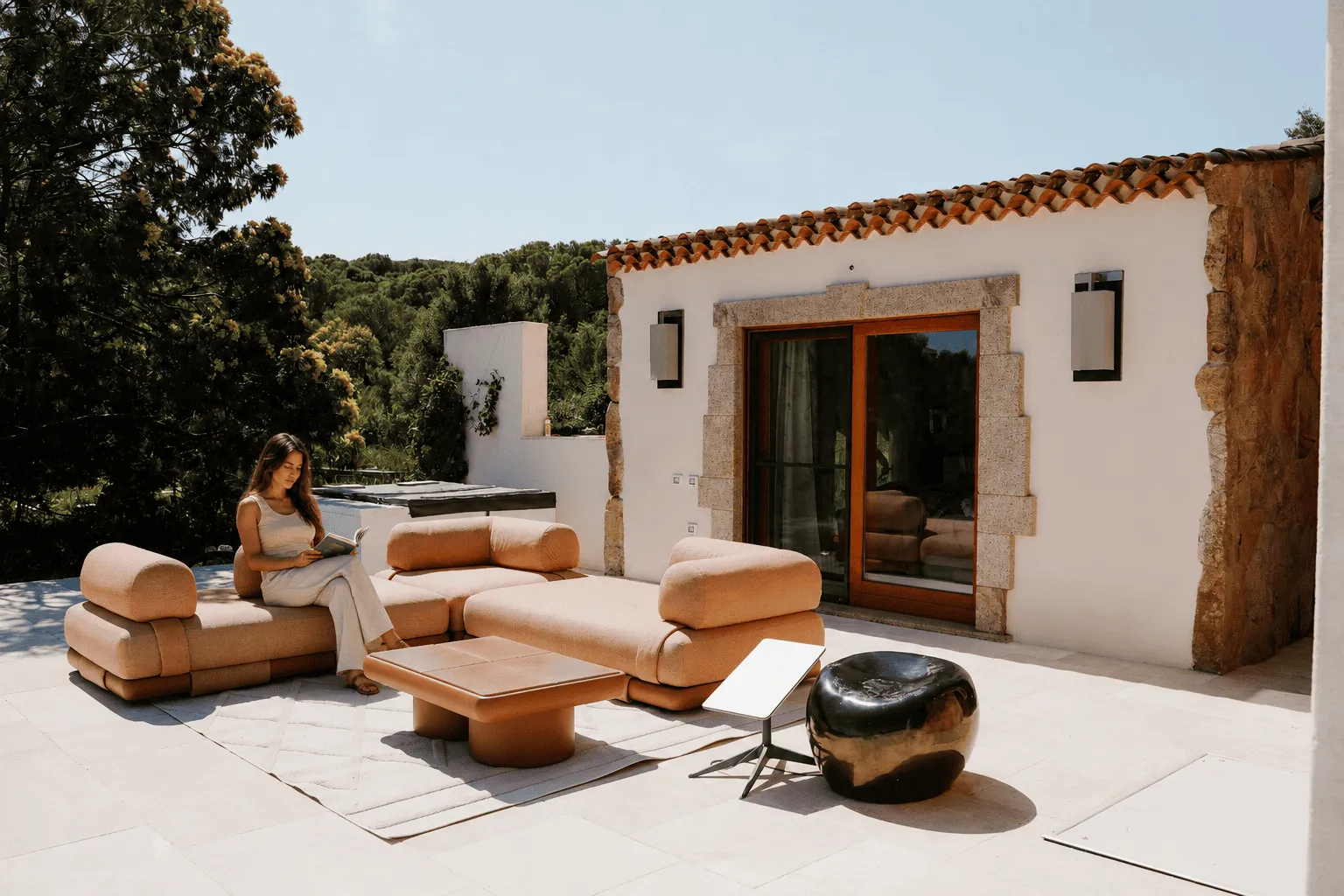 FitnWrk Retreat Finca auf Sardinien Bild von einer Couch Area wo eine Frau ein Buch liest